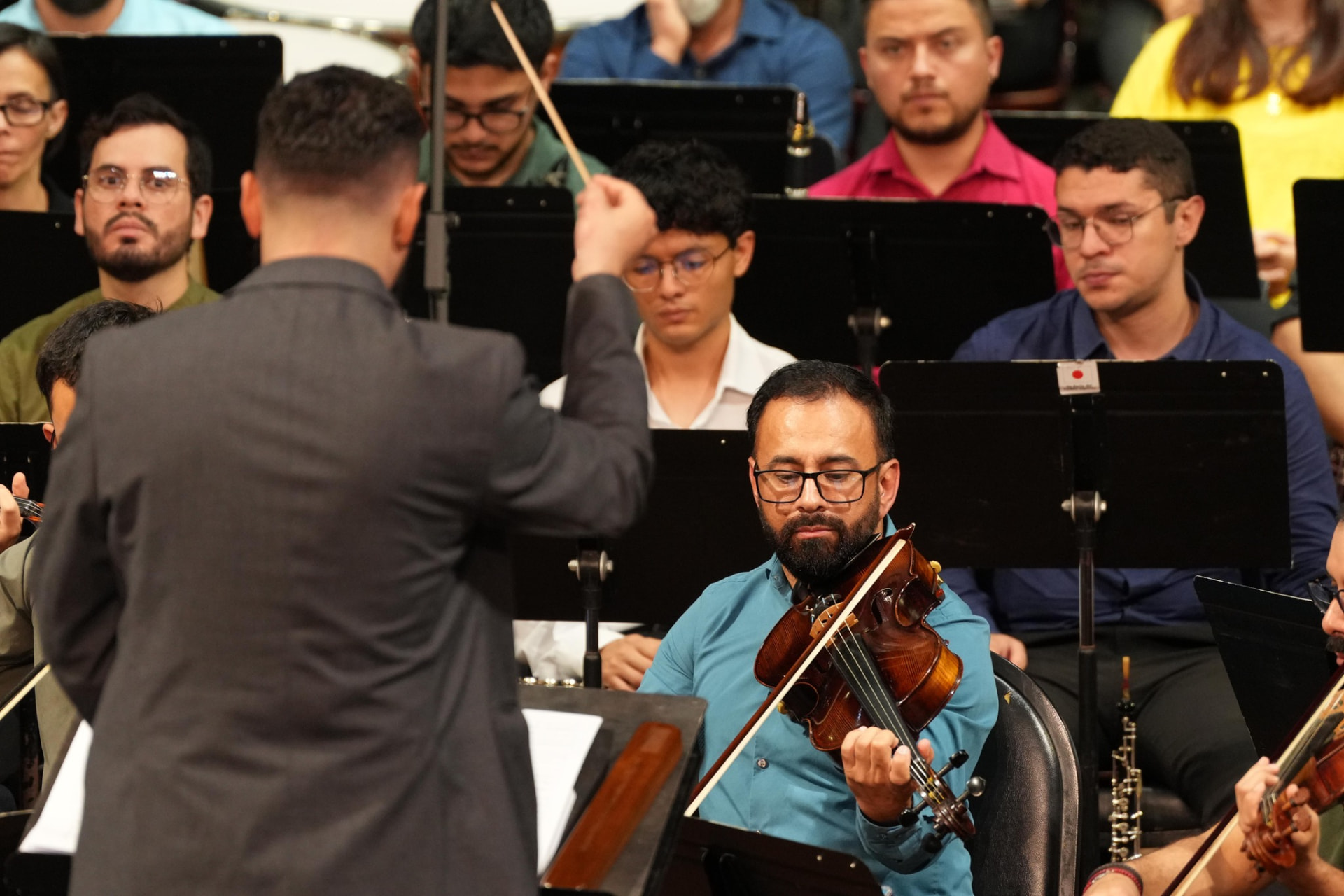 El director Didier Mora frente a la orquesta durante la grabación